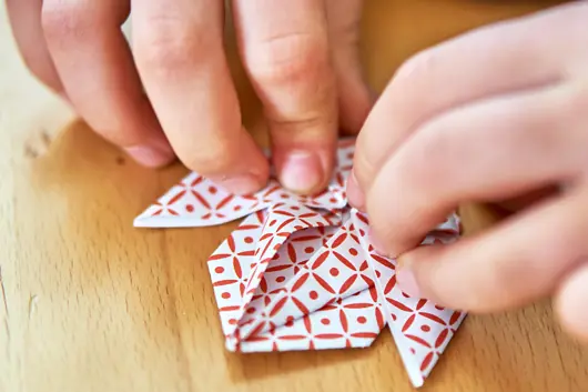 Hands folding origami paper